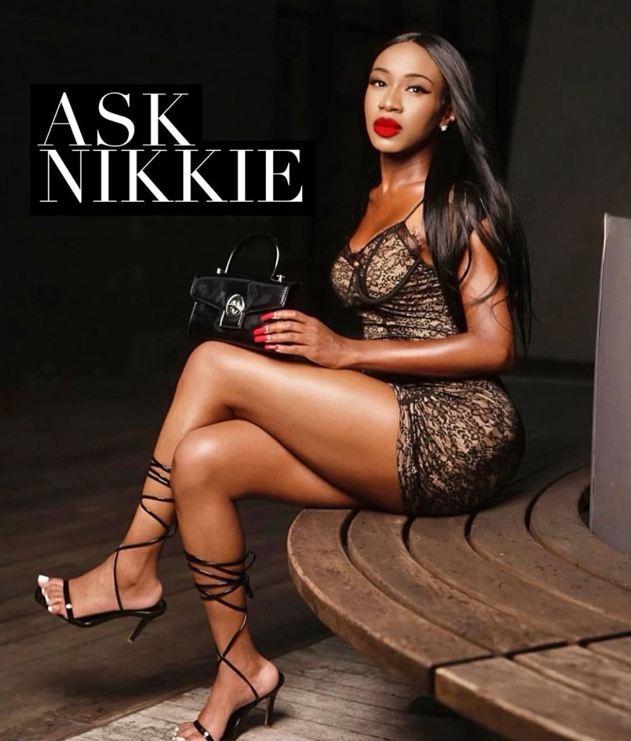 Nikkie seated on a wooden bench, with the Ask Nikkie logo